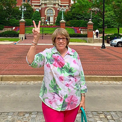 Sandy Bass flashes a victory sign in front of The Johns Hopkins Hospital