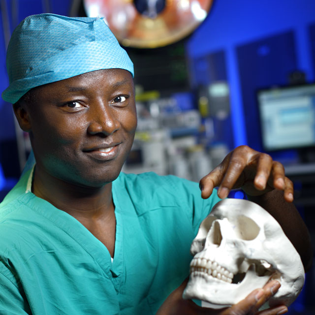 Surgeon Kofi Boahene holding model of human skull
