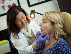 doctor examining a woman's mouth