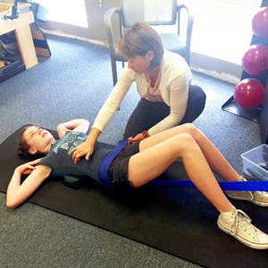 Peiting Lien with patient Sophie, helping her with scoliosis exercises