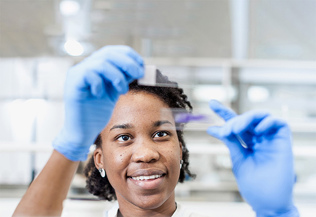 woman looks at vials in lab