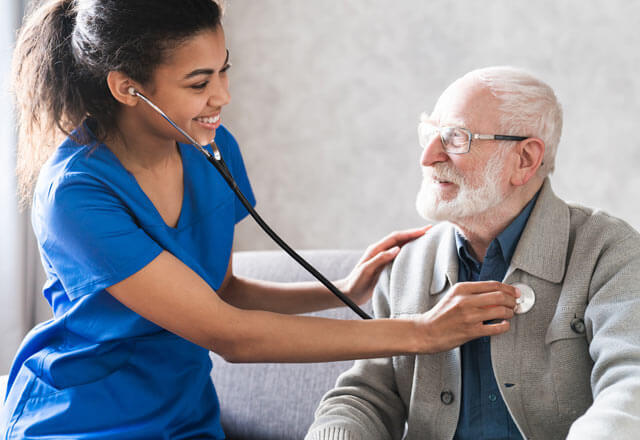 Nurse checks heartbeat of elderly patient