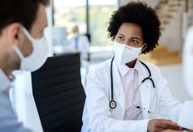 Two doctors with masks look at each other