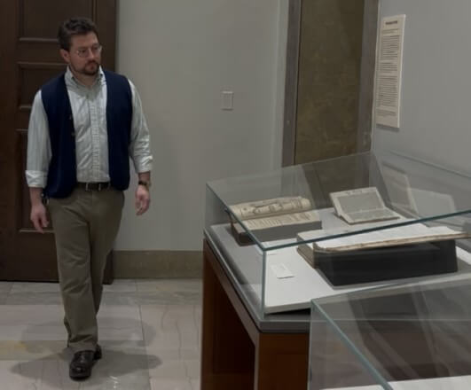 Photo of Michael Seminara walking past a book exhibit