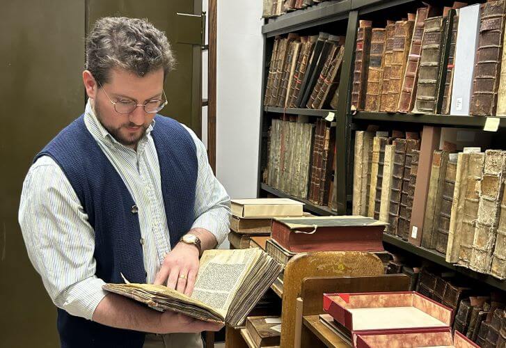 Photo of Michael Seminar examining rare books in a vault