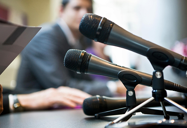A close-up of microphones during a panel discussion
