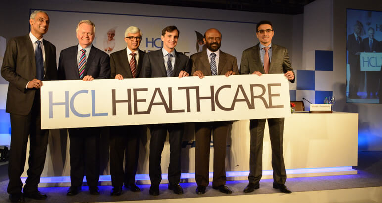 Executives holding up a HCL Healthcare sign.
