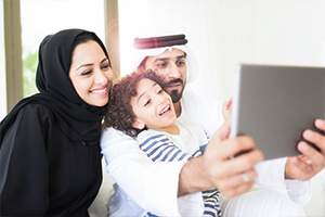 family smiles while viewing tablet