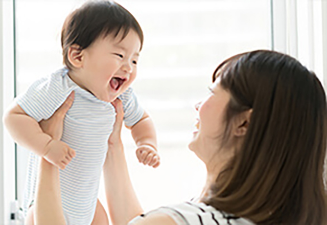 mother picking up laughing baby