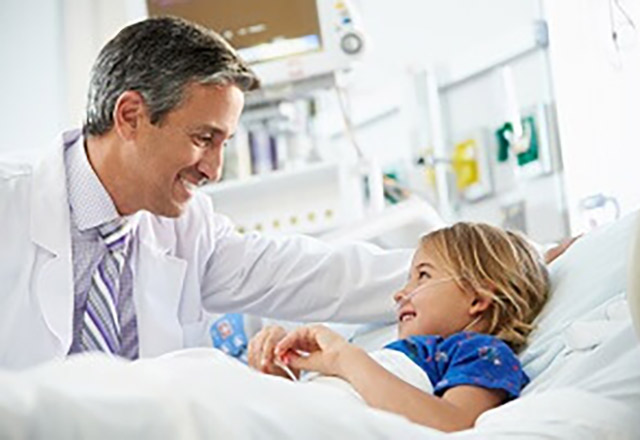 little girl talking to doctor from hospital bed