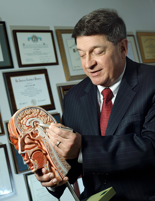 Alan Cohen, M.D. with a model of a brain