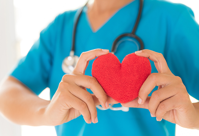 A nurse holds up a felt heart