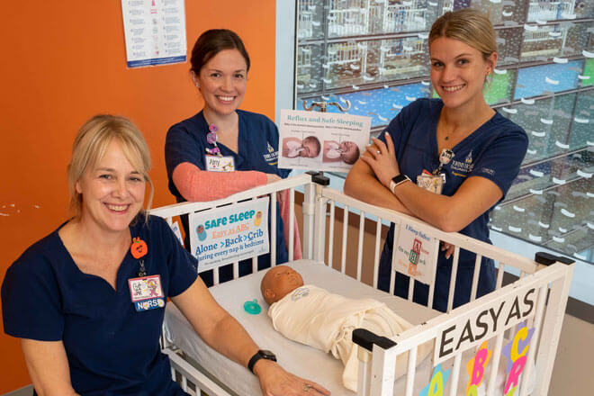 nurses standing by an example crib