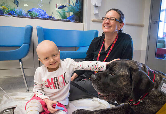 a child and doctor enjoy pet therapy