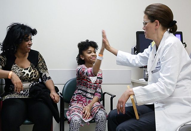 dr jaliyah gives a child a high five