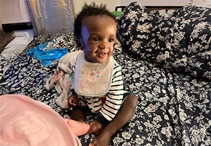 Asante sitting on a bed