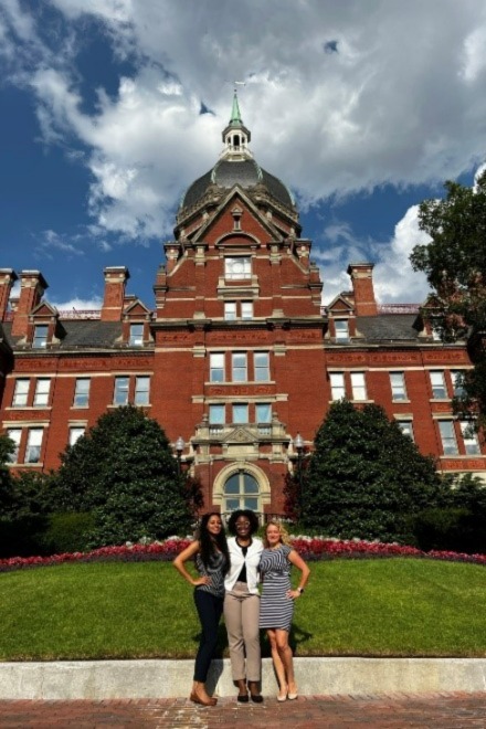 three fellows stand outside of johns hopkins