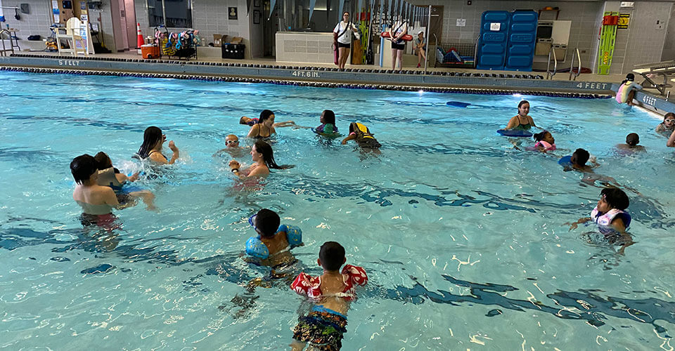 children swimming at camp charm city