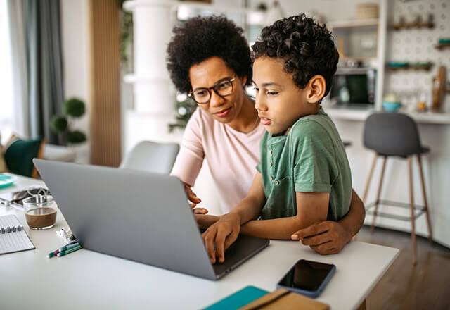 A mother and her son sit at a computer attending a virtual IBD Support Group session