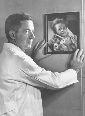 Dr. Blalock with a portrait of a blue-baby patient on the wall
