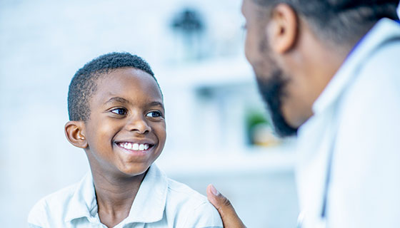 Young boy smiling at pediatric doctor