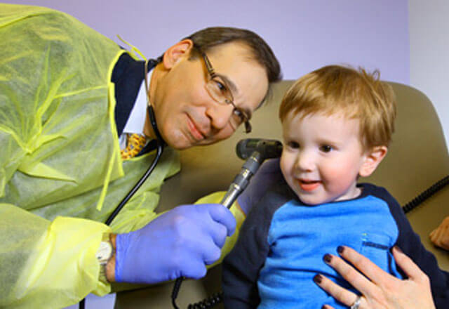 Peter Mogayzel examines a child's ear in the Johns Hopkins Children's Center