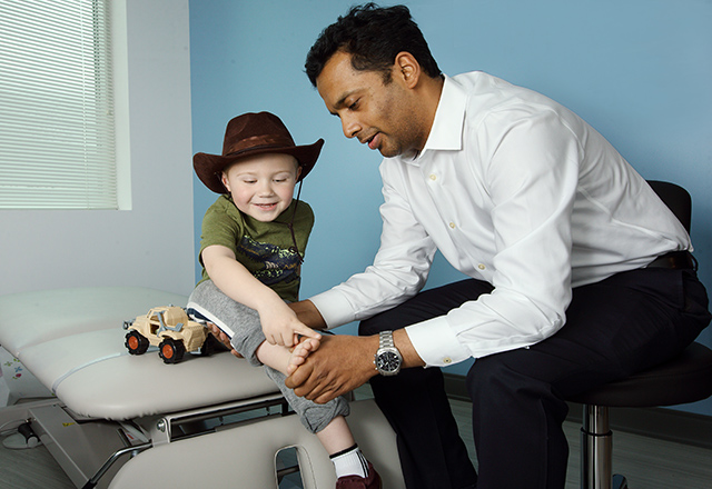 doctor checks on a child wearing a cowboy hat