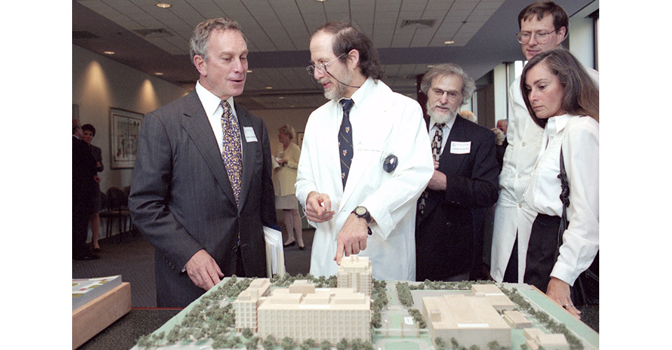 Michael Bloomberg (left) and Dr. Bert Vogelstein look over building plans. Drs. Stephen Baylin and Kenneth Kindler are seen in the background