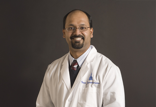 Dr. Vasan Yegnasubramanian in his white lab coat.