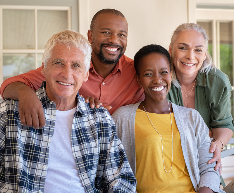 Smiling group of 4 middle aged people. Two men and two women.