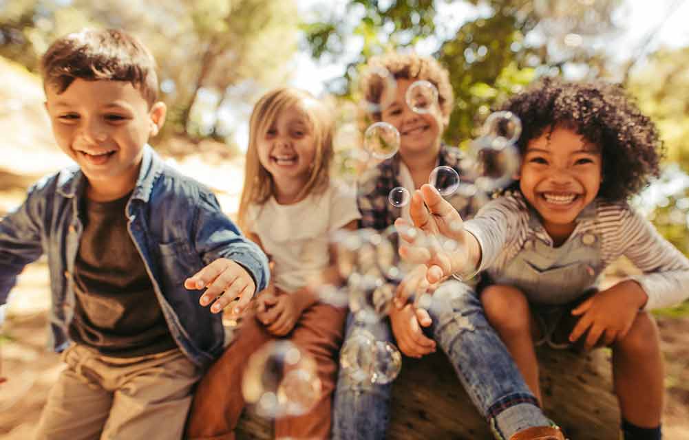 Smiling children with bubble in the park