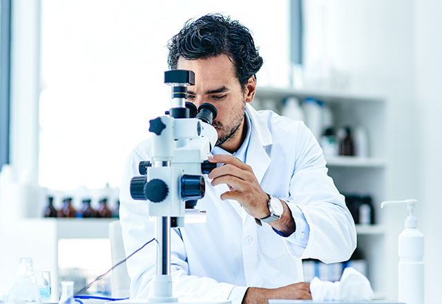male scientist using microscope