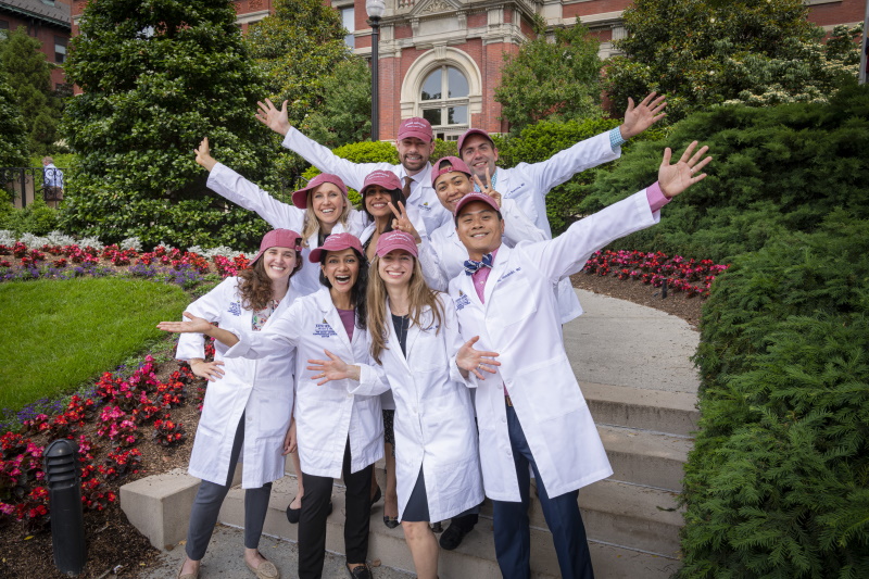 Fellows in white coats with hands up in celebration