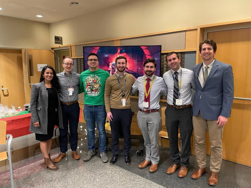Six fellows in front of a television screen