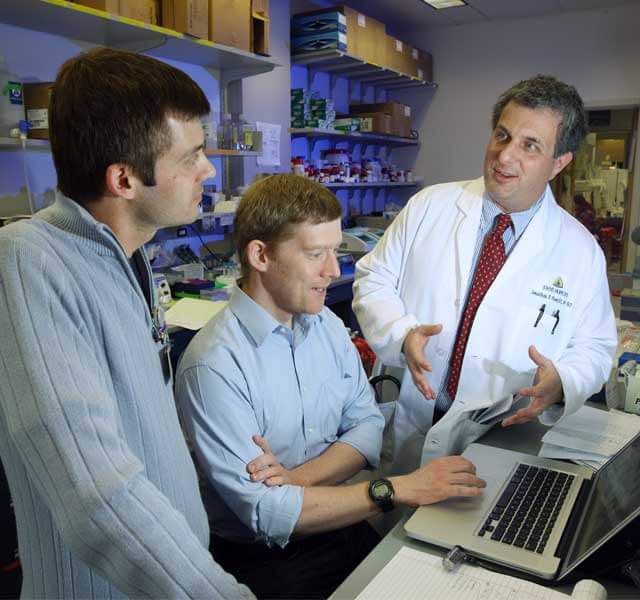 Jonathan Powell talking with others in the lab