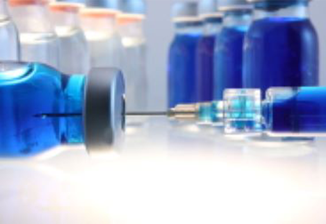 A syringe with a needle draws blue liquid from a vial, surrounded by other blue-capped vials. The image conveys a clinical, sterile medical tone.