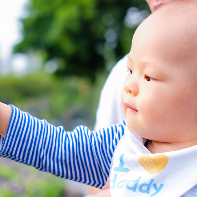 Asian Little toddler boy is  at park in springtime looking and pointing finger