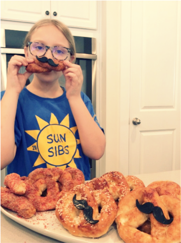 SunSibs camper makes pretzels with a mustache
