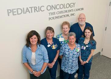 nurses in front of pediatric oncology signage wall