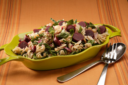 Beet and pasta salad in a colorful serving dish.