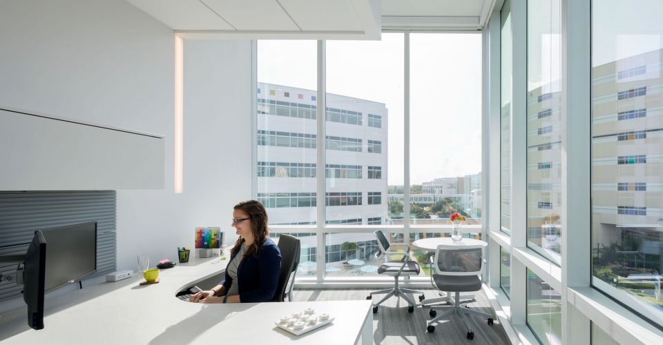 A woman sitting at her desk at the Johns Hopkins All Children's Hospital Research and Education Building.
