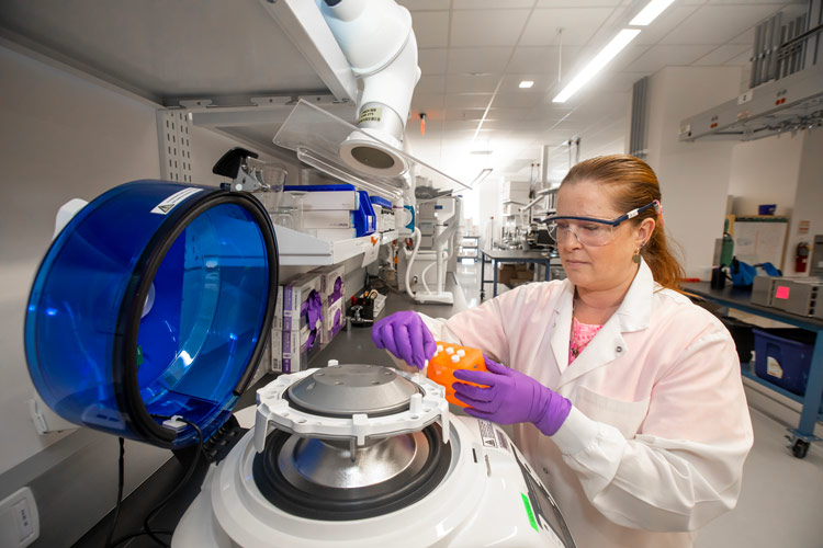 A researcher putting samples in a centrifuge