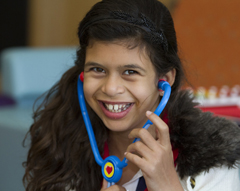 A girl playing with a toy stethoscope