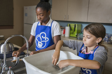 Two children working together during a cooking class.