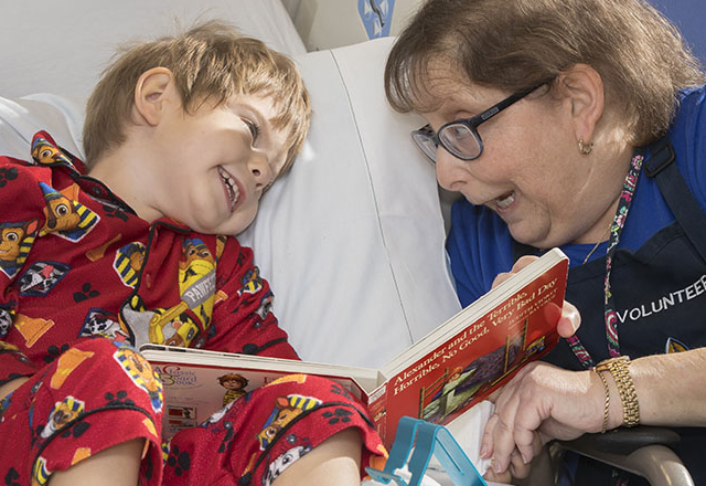 Sharon Wurster, volunteer, reads to three-year-old Cole