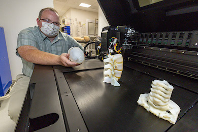 Simulation engineer Matthew Lee with the new 3-D printer, which can create precise models of anatomy, including specific diagnoses or pathology.