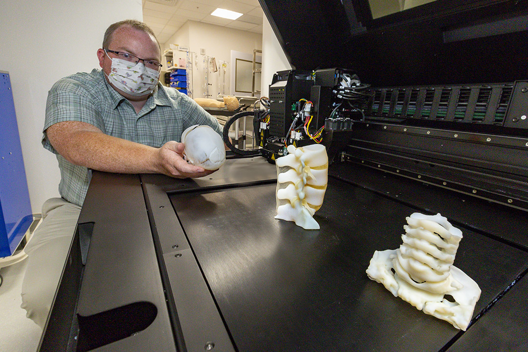 Simulation engineer Matthew Lee with the new 3-D printer, which can create precise models of anatomy, including specific diagnoses or pathology.