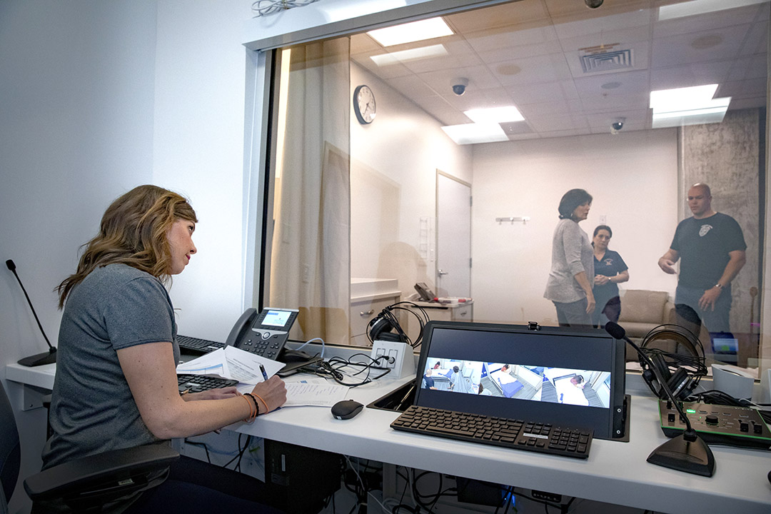 Lauren Gardner, Ph.D., administrative director of the autism program at Johns Hopkins All Children's, observes how officers deescalate a simulated call involving a teenager with Autism Spectrum Disorder (ASD) in the hospital’s Center for Medical Simulation and Innovative Education, in this photo from 2019.