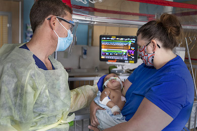 Anthony A. Sochet, M.D., MHSc,, with an infant patient and another member of the care team at Johns Hopkins All Children's Hospital