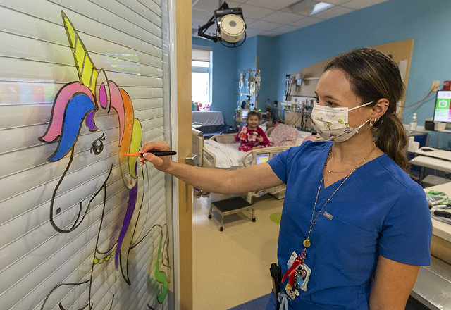 Sandra Vizer, R.N., works on a mural for a patient in the CVICU.